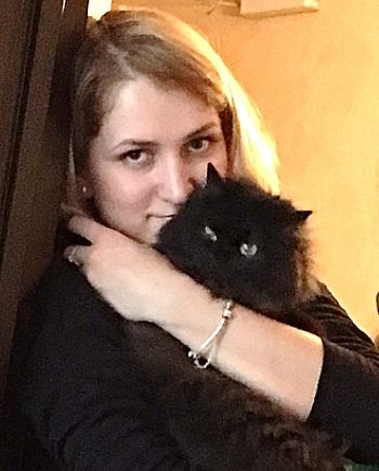 Чёрная персидская кошка на руках